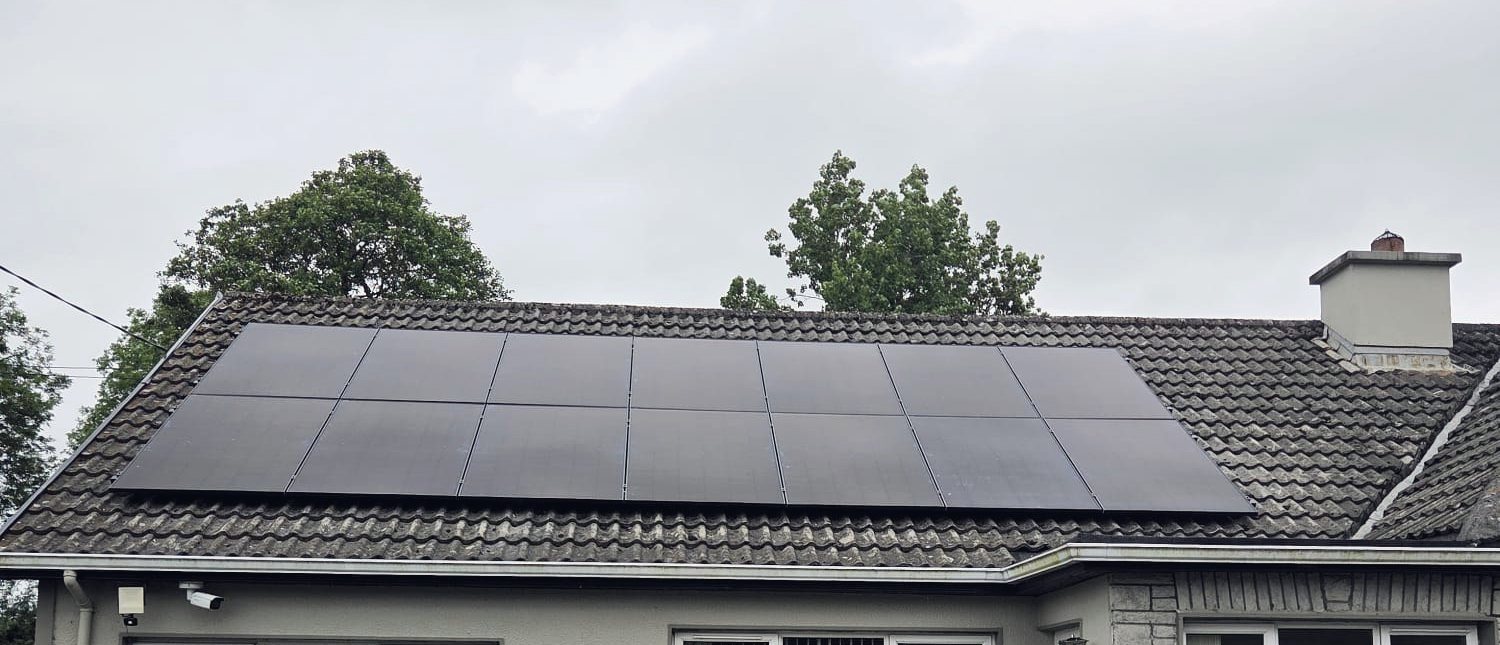 All-black solar panels on a bungalow roof under an Irish sky