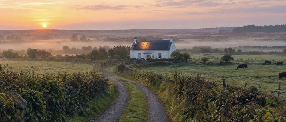 Sunrise over fields and a farmhouse in the Irish Midlands
